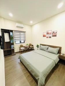 a bedroom with a large bed and a table at Rio Guest House - Phú Quốc in Phú Quốc