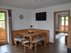 uma sala de jantar com uma mesa de madeira e cadeiras em Lovely apartment in Gaißach em Gaißach