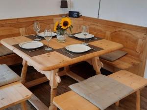 a wooden table with wine glasses and a vase with a sunflower at Lovely apartment in Gaißach in Gaißach