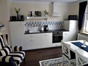 a kitchen with white cabinets and a table and a couch at Holiday apartment Randersacker in Randersacker