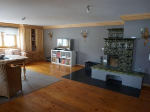 - un salon avec une cheminée et un canapé dans l'établissement Apartment in the Waxenegg country house, à Sulzberg