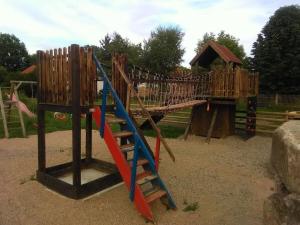 einen Holzspielplatz mit Rutsche in einem Park in der Unterkunft Nice apartment in Himmelkron in Himmelkron