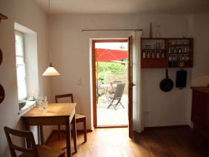 uma sala de jantar com uma mesa e uma porta para um pátio em Pleasant apartment in Diessen 