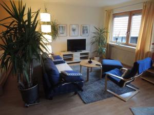 - un salon avec un canapé, des chaises et une télévision dans l'établissement Apartment 2 Mainblick Brigitte, 