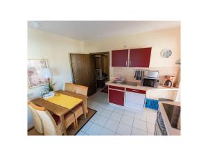 - une cuisine avec des placards rouges et une table dans l'établissement Apartment 2 Mainblick Brigitte, 