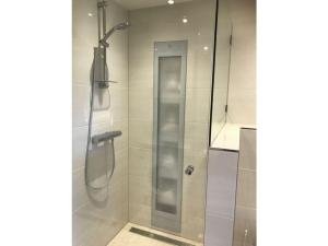 a shower with a glass door in a bathroom at Holiday home Zanddrijver in Makkum