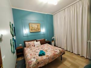 a bedroom with a bed with a blue wall at GARDEN in Milan