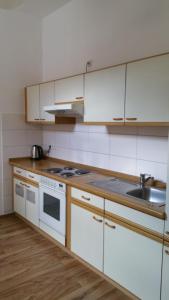 a kitchen with white cabinets and a sink at Pension Anna in Rastatt