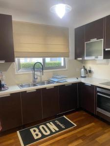 a kitchen with brown cabinets and a sink and a window at Hill Luxury Family Maisonette 21 in Ayios Dhometios