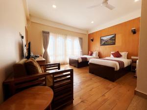 a hotel room with two beds and a table at Paro Eco Lodge in Paro