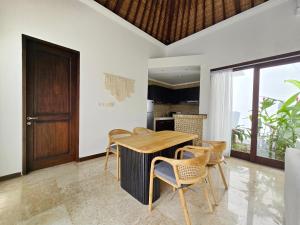 a dining room with a wooden table and chairs at Villa Venta by Maheswara in Uluwatu