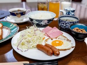 um prato de comida de pequeno-almoço com ovos, salsicha e salada em Tabist Kotohikisou em Kanonji