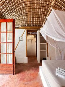 a room with a bed and a ladder and a window at KUA Cabañas in Palomino