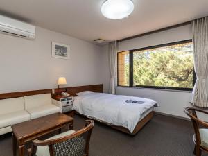 um quarto de hotel com uma cama e uma janela em Tabist Kotohikisou em Kanonji