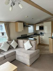 a living room with a couch and a kitchen at Harries Lodge 2 Aberaeron in Aberaeron