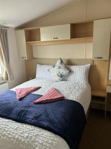 ein Schlafzimmer mit einem Bett mit zwei Handtüchern darauf in der Unterkunft Harries Lodge 2 Aberaeron in Aberaeron