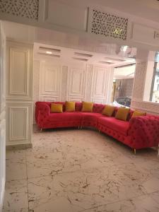 ein rotes Sofa mit gelben Kissen im Wohnzimmer in der Unterkunft HOTEL K2 INN , Srinagar in Srinagar