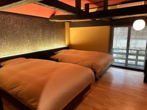 a bedroom with two beds in a room at 藤左ヱ門の宿 in Sudagai