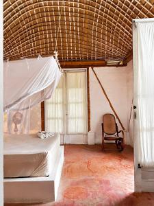 a bedroom with a bed and a chair in it at KUA Cabañas in Palomino