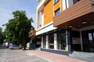 un bâtiment sur le côté d'une rue avec une voiture dans l'établissement Hotel Forum City, à Pazardjik