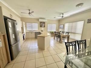 cocina y sala de estar con mesa y sillas en Hinchinbrook Resorts Management Pty Ltd, en Lucinda