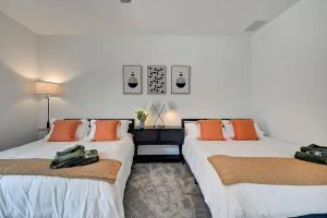 two beds in a room with orange pillows at NEW Luxury Home 10 Min To Downtown Pool Table in Indianapolis