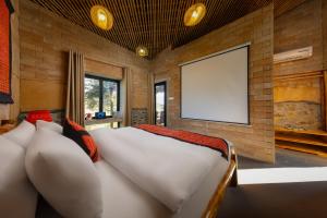 a bedroom with a white bed and a blank screen at Sapaxa Spring Garden Ecolodge in Sapa