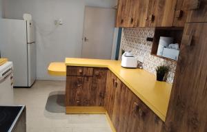 a kitchen with a yellow counter and a refrigerator at Private separate unit - A in O'Connor in Canberra