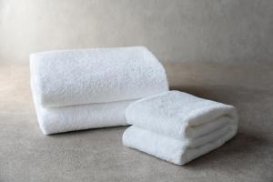 una pila de toallas blancas sentadas en un mostrador en Grand Mercure Lake Hamana Resort & Spa, en Hamamatsu