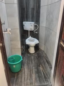 - une petite salle de bains avec des toilettes et un seau dans l'établissement New G P Guest house, à Ujjain