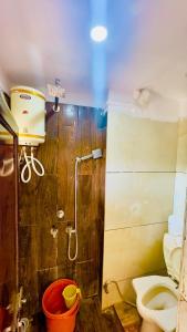 La salle de bains est pourvue d'une douche, de toilettes et d'un seau. dans l'établissement New G P Guest house, à Ujjain