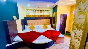 um quarto com uma cama com um cobertor vermelho em New G P Guest house em Ujaim