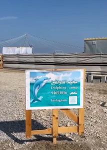 a sign for a dolphin camp in the ocean at Dolphin Campground in Barka