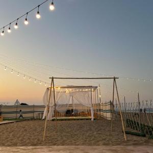Dolphin Campground في بركاء: خيمة على الشاطئ مع أضواء عليها