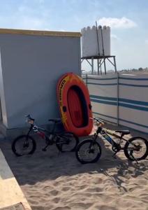 two bikes parked next to a building on the beach at Dolphin Campground in Barka