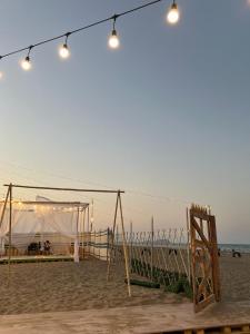 ein Zelt und eine Schaukel am Strand in der Unterkunft Dolphin Campground in Barka