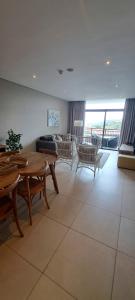 een grote woonkamer met een tafel en stoelen bij Zimbali Suites 505 in Ballito