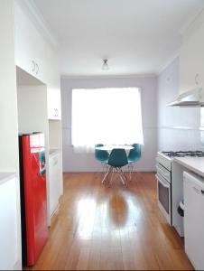 eine Küche mit einem roten Kühlschrank und einem roten Stuhl in der Unterkunft Peaceful cozy home in Kennington