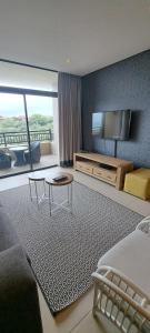 een woonkamer met een bank en een tv bij Zimbali Suites 505 in Ballito