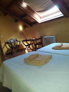 a bedroom with two beds and a table with a window at CASA OSO 1 in Pola de Somiedo