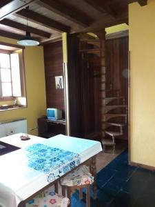 a dining room with a table and two stools at CASA OSO 1 in Pola de Somiedo