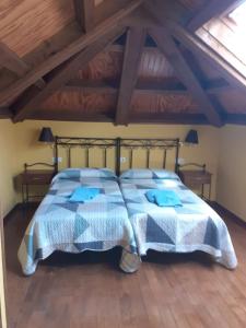 a bedroom with a bed with blue and white blankets at CASA OSO 1 in Pola de Somiedo