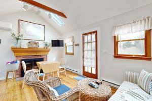 a living room with a table and chairs and a fireplace at Cozy Escape on the Cape in Eastham