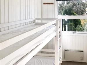 Holiday home Middelfart IV في ميدلفارت: سرير بطابقين أبيض في غرفة مع نافذة