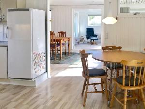 a kitchen and dining room with a table and a refrigerator at Holiday home Middelfart IV in Middelfart