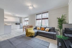 a living room with a couch and a kitchen at Spacious 1 Bed Apartment- Close to Kings Cross Station in London