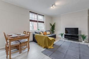 - un salon avec une table et un canapé dans l'établissement Spacious 1 Bed Apartment- Close to Kings Cross Station, à Londres