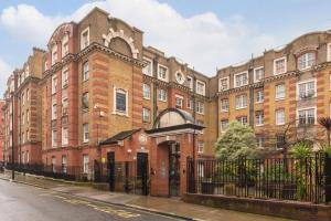 a large brick building with a gate in front of it at Spacious 1 Bed Apartment- Close to Kings Cross Station in London
