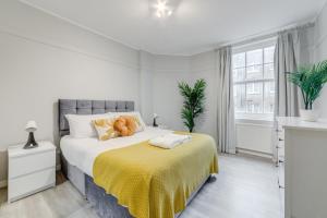 a bedroom with a large bed with a yellow blanket at Spacious 1 Bed Apartment- Close to Kings Cross Station in London