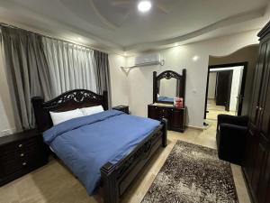 a bedroom with a bed and a mirror and a chair at Amro Petra Apartment in Wadi Musa